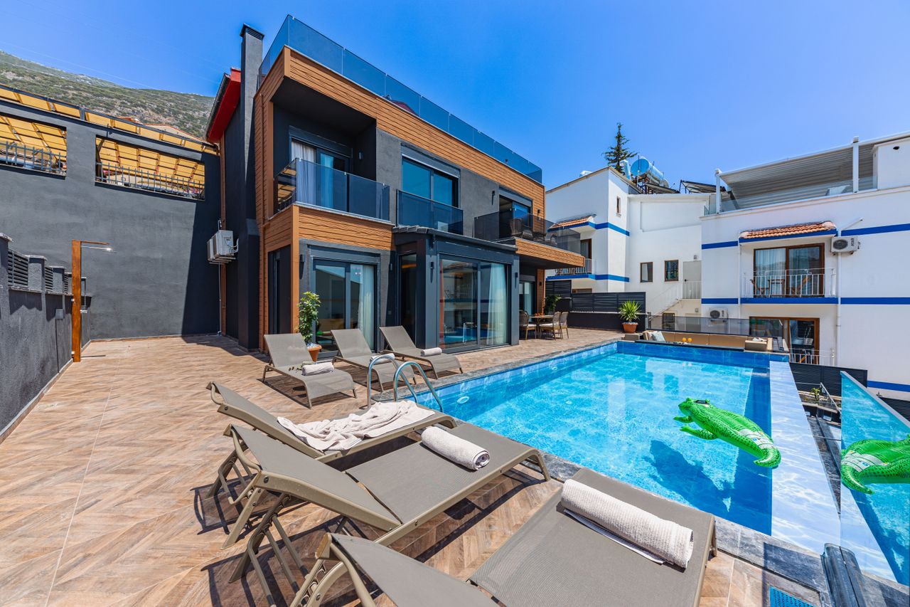 Contemporary villa with a private swimming pool and sun loungers, ideal for a luxury vacation.